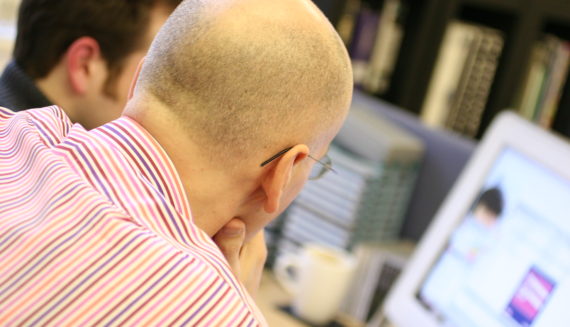 Two men looking at a computer