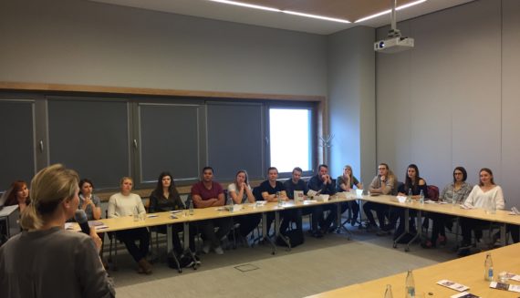 Students from Ostfalia University sitting at a table and listening to a presentation on the topics of Accounting, HR and Payroll prepared by getsix®