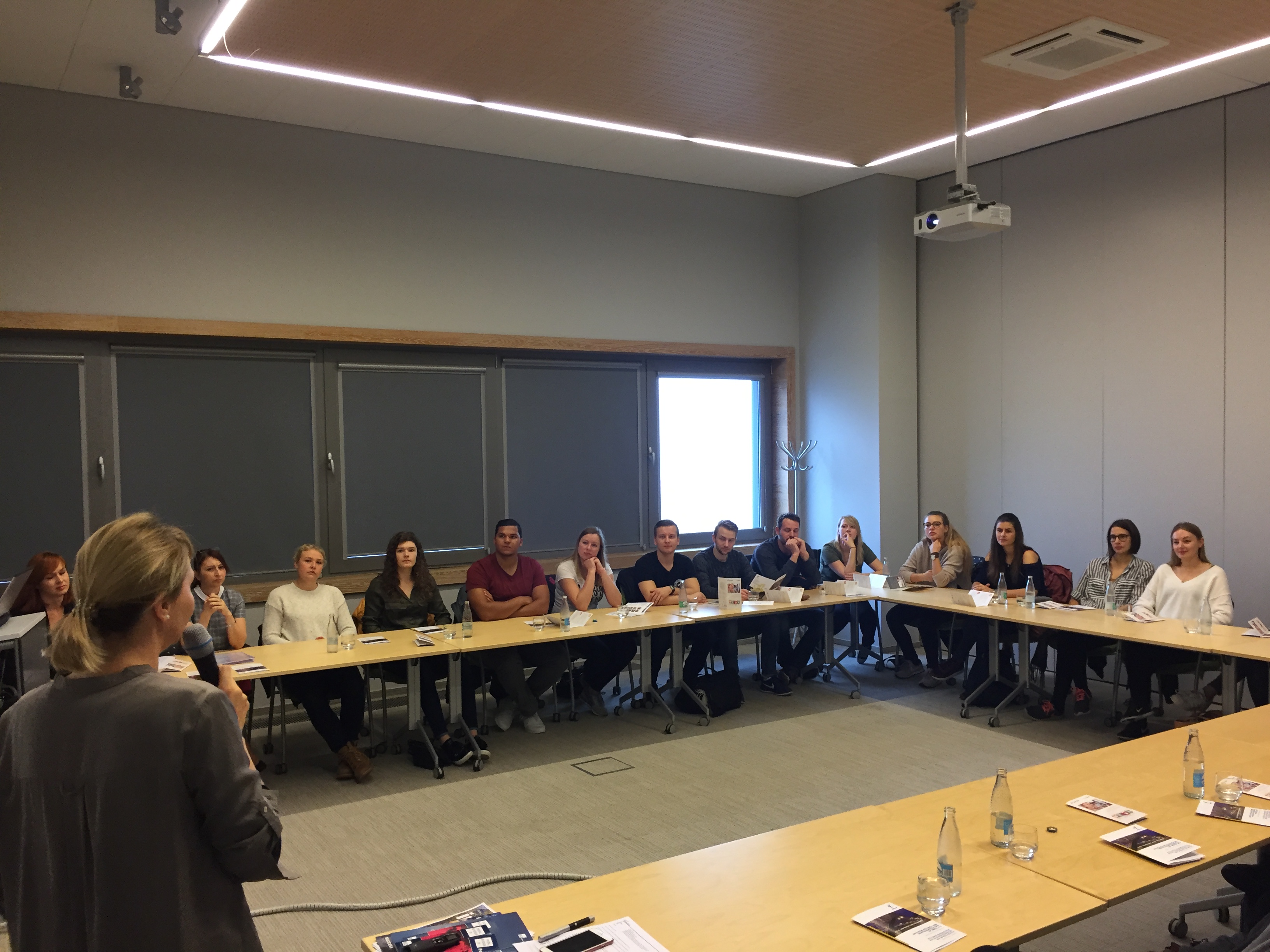 Students from Ostfalia University sitting at a table and listening to a presentation on the topics of Accounting, HR and Payroll prepared by getsix®