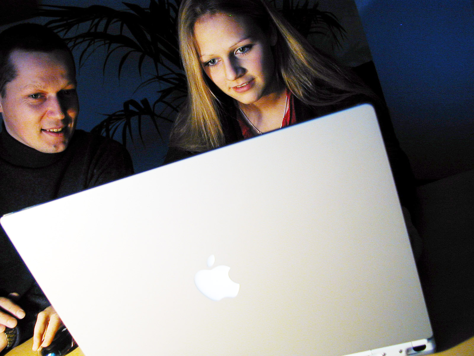 Two people using a laptop