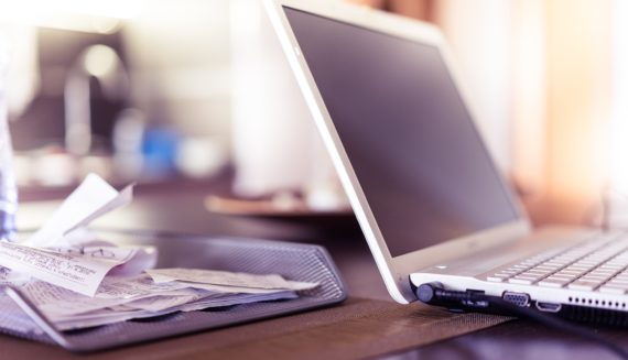 A laptop next to the receipts