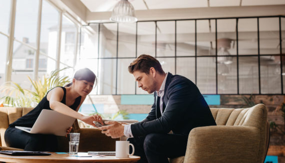 A woman showing a man something on the phone