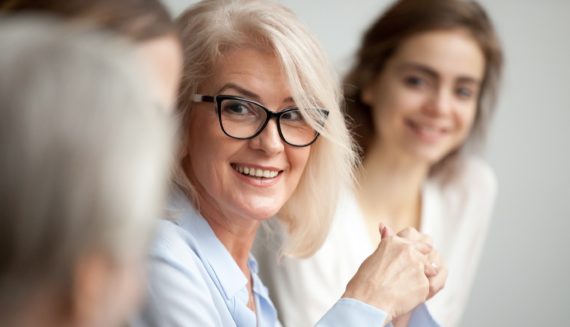 A woman with glasses smiling