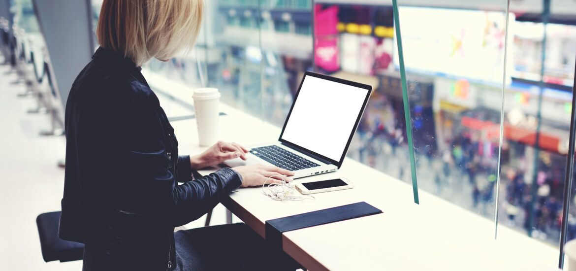 A woman with a cup of coffee using her laptop