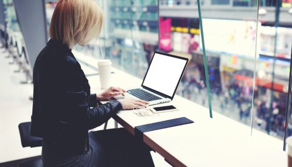 A woman with a cup of coffee using her laptop