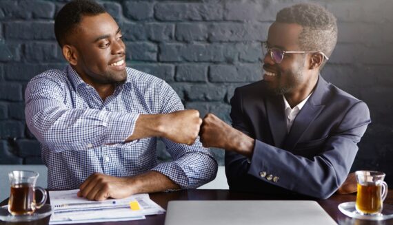 Two men fist bumping each other