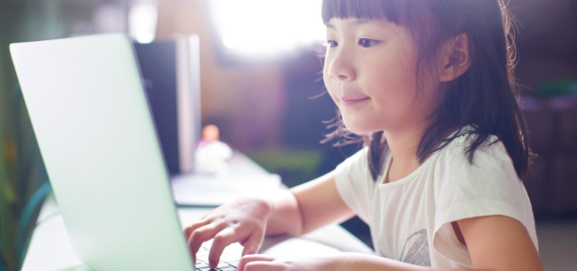 A little girl using her laptop