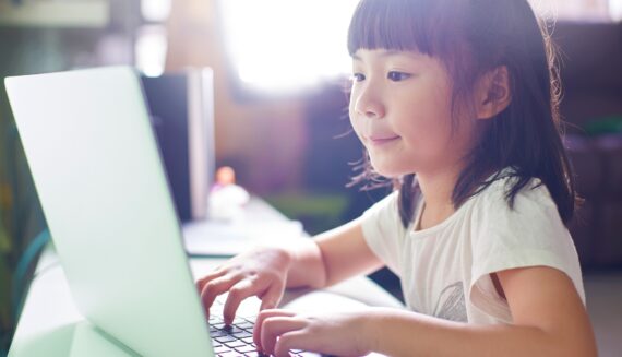 A little girl using her laptop