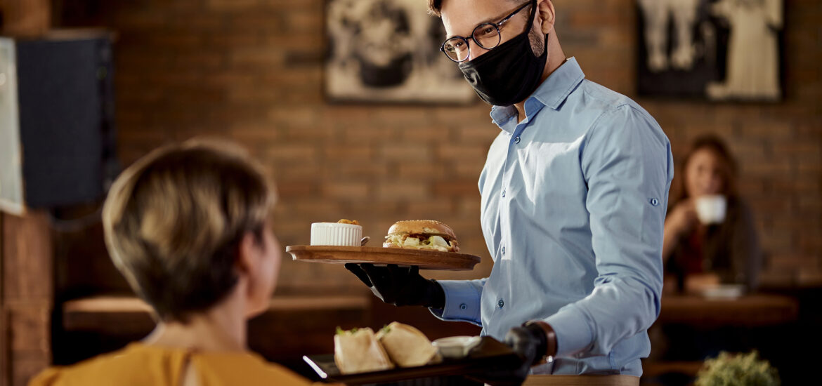 A waiter wearing a mask