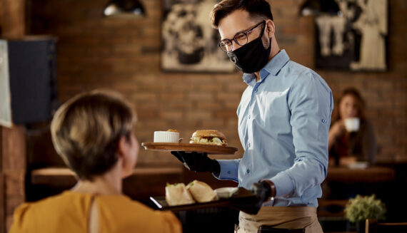 A waiter wearing a mask