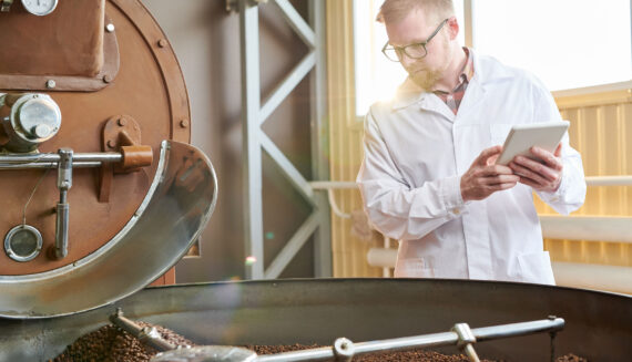 A man in apron looking at coffee beans