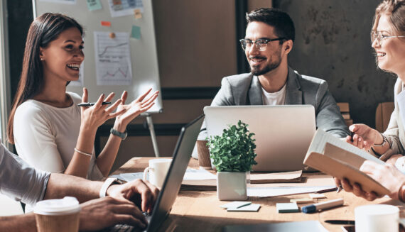 A group of people with laptops smiling and talking